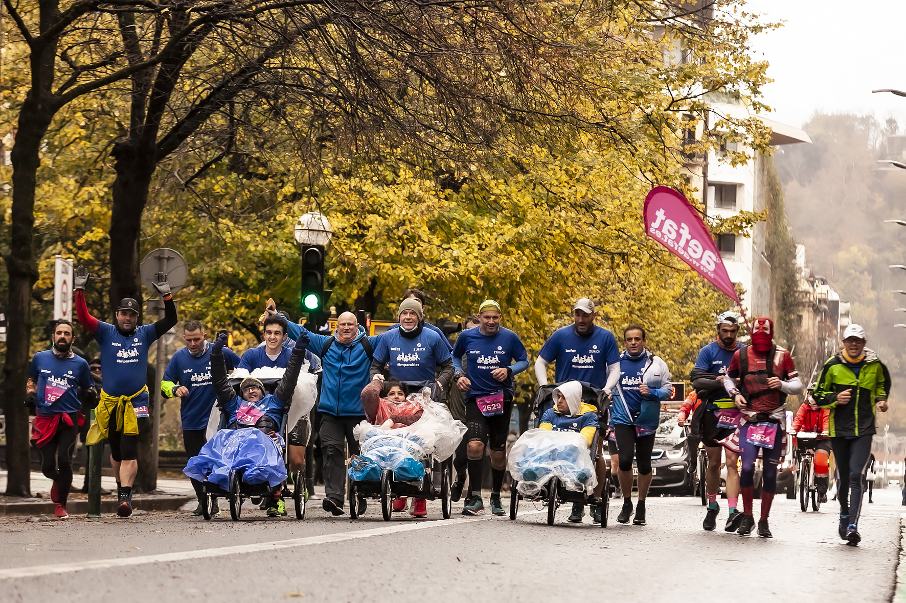 Gonzalo lleva silla de chico capucha blanca Equipo Zurich Aefat en Maratón San Sebastián 2021 llegando